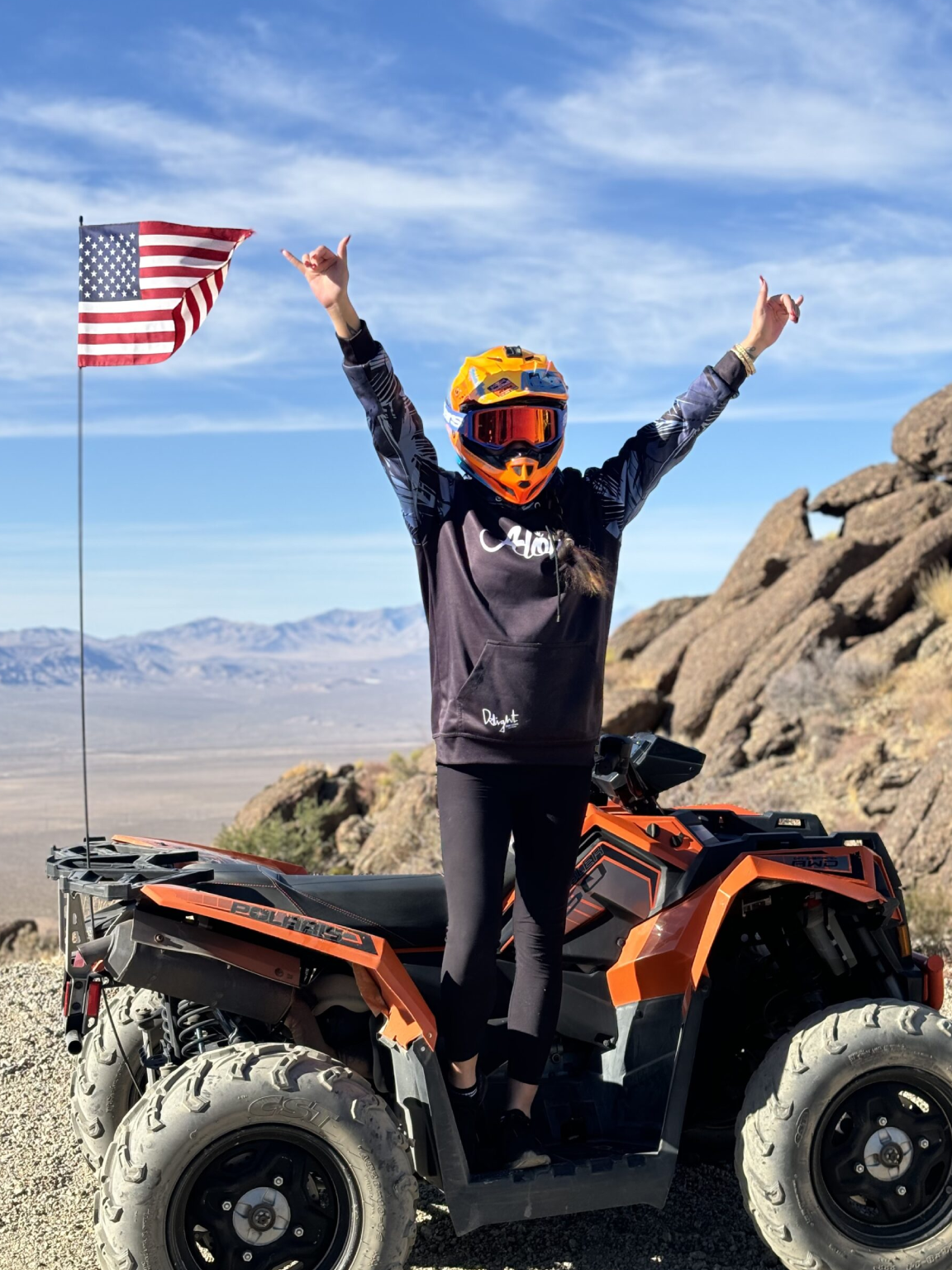 A person on an atv with the american flag in the background.